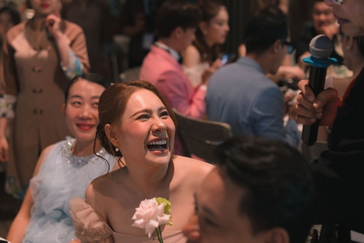 Ca sĩ Hồ Bích Trâm cùng ông xã đi ăn cưới, cười rạng rỡ khi được MC đề nghị giao lưu với khách mời.