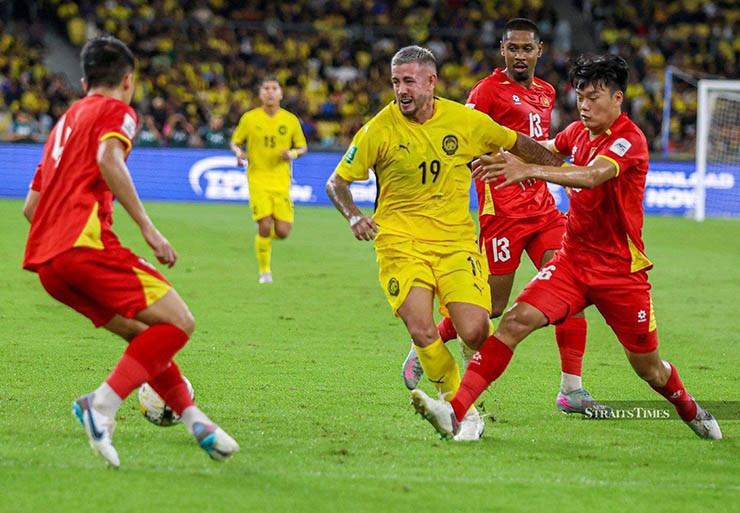 ĐT Malaysia (áo vàng) phạm luật trong trận đấu với ĐT Việt Nam
